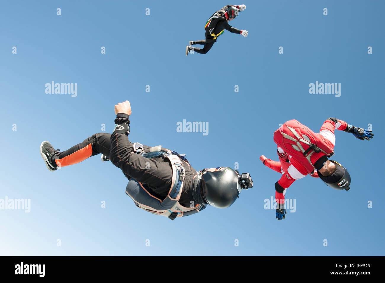 Tre skydivers Tumbling attraverso l'aria dopo exitig l'aereo Foto Stock Tre skydivers Tumbling attraverso l'aria dopo exitig l'aereo Foto Stock