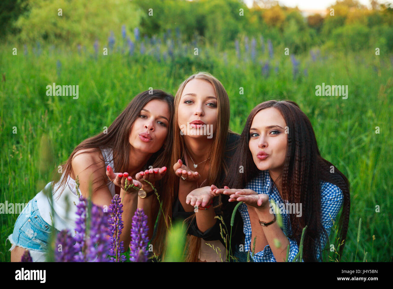 Tre belle giovani ragazze felici migliori amici manda un bacio aria , a sorridere e ridere Foto Stock