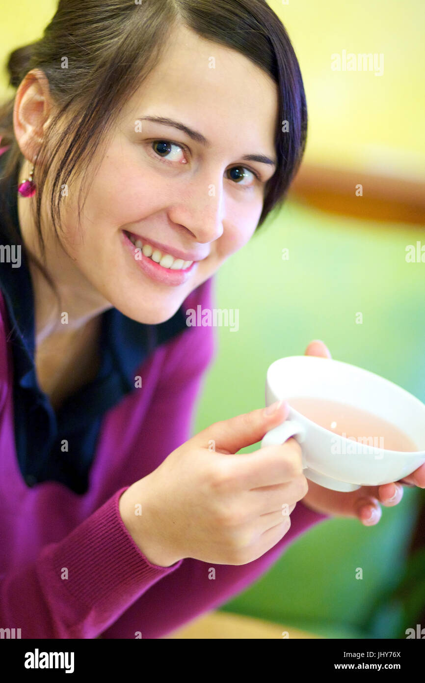 Giovane donna si riscalda se stessa in una tazza di tè - Giovane donna con una tazza di tè, Junge Frau wärmt sich un einer Tasse Tee - una giovane donna con una tazza di tè Foto Stock