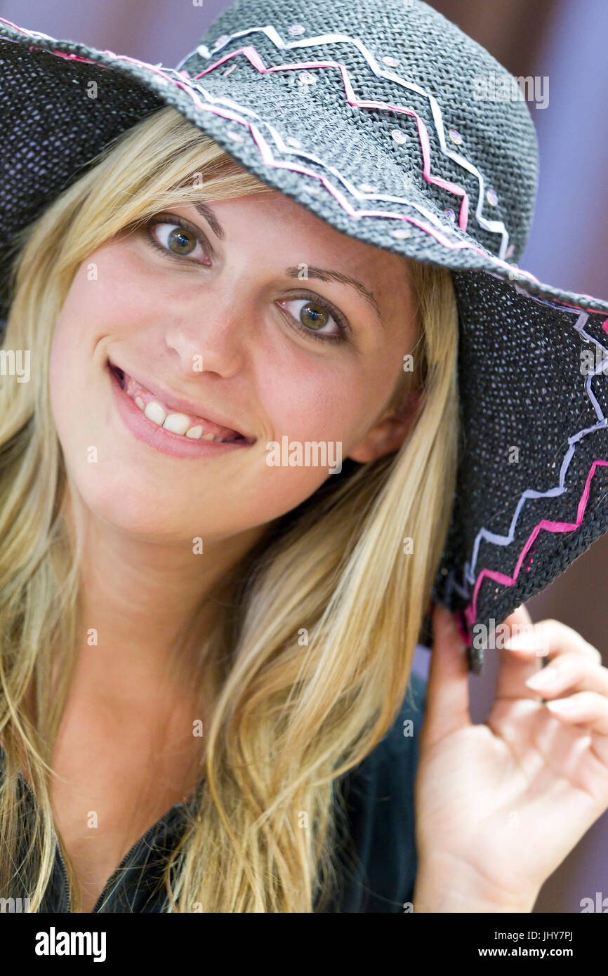 Giovane donna con cappello solare - una giovane donna che indossa un sun ha, Junge Frau mit Sonnenhut - una giovane donna che indossa un cappello per il sole Foto Stock