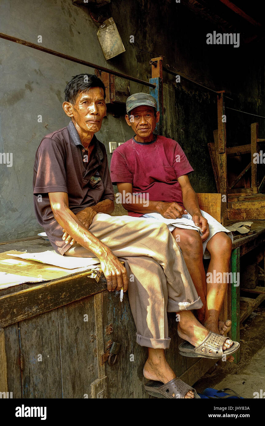 Due maschi residenti sit in strada a Jakarta, Indonesia Foto Stock