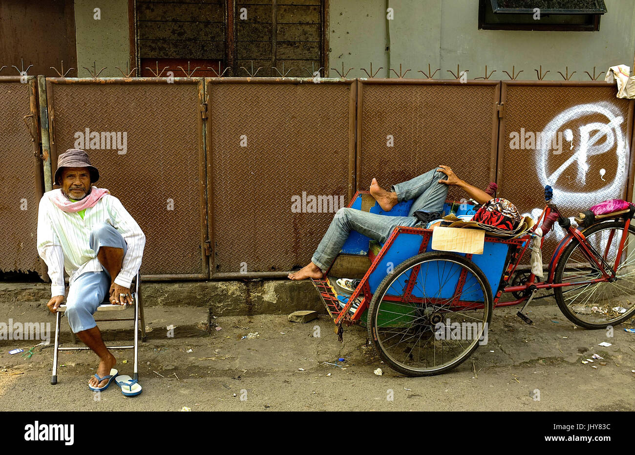 Due maschi residenti sit in strada a Jakarta, Indonesia Foto Stock