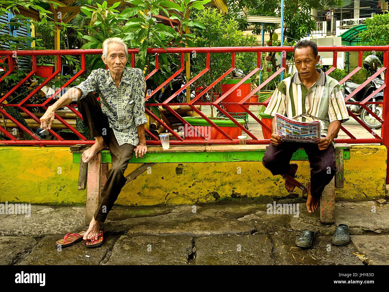 Due maschi residenti sit in strada a Jakarta, Indonesia Foto Stock