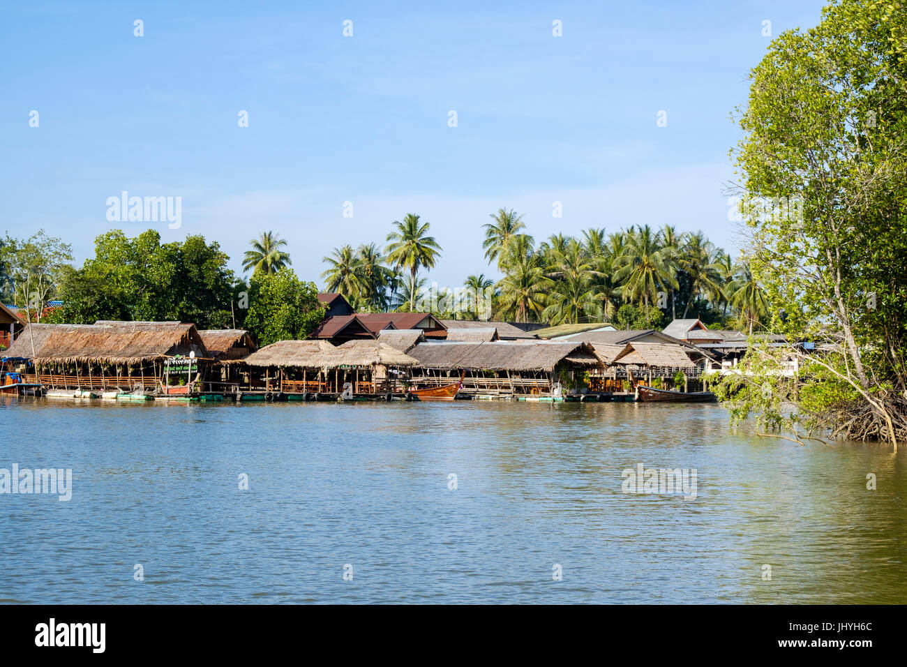 Case galleggianti e longtail barche di linea uno dei canali a est di Krabi town e il fiume, Provincia di Krabi, Thailandia. Foto Stock