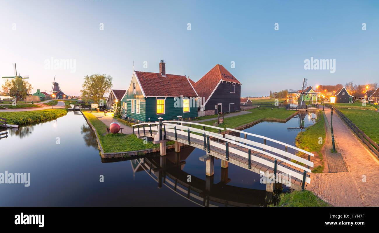 Panorama di case di legno e i mulini a vento del tipico villaggio di Zaanse Schans al crepuscolo, North Holland, Paesi Bassi, Europa Foto Stock