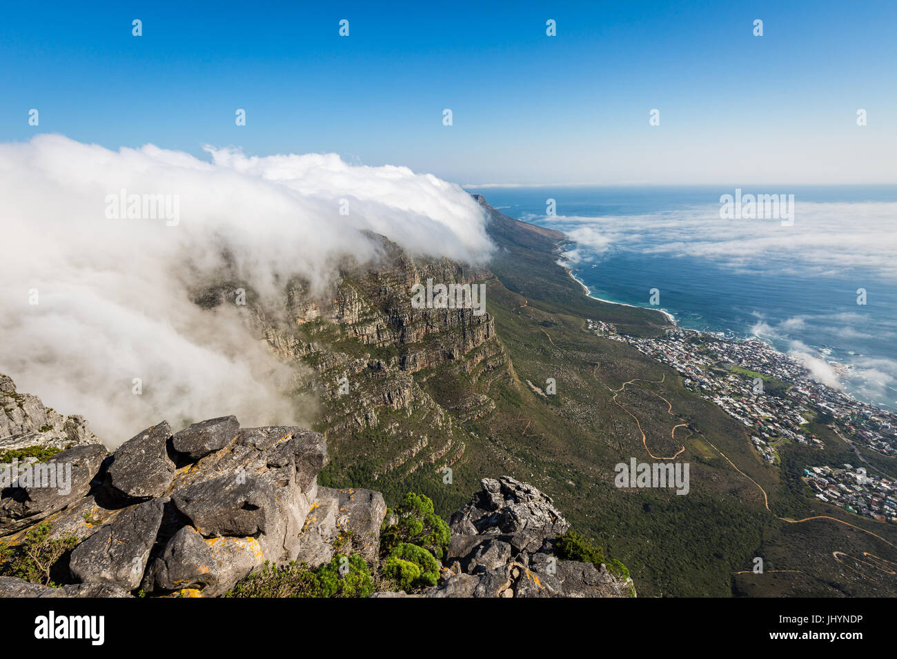 Table Mountain ricoperto di una tovaglia di nubi orografiche, Camps Bay al di sotto di coperte di bassa cloud, Cape Town, Sud Africa Foto Stock