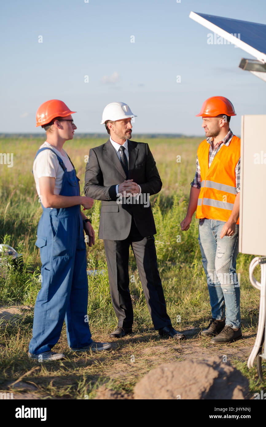 Testa di energia solare stazione parlando con gli ingegneri. Foto Stock