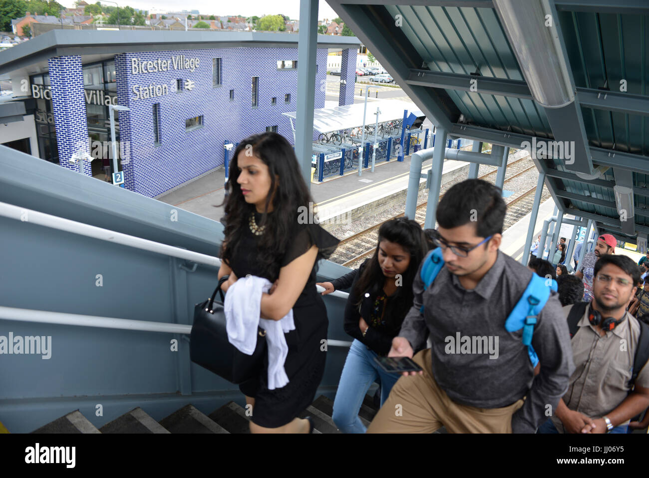 Gli acquirenti che arrivano presso il Villaggio di Bicester rail station Foto Stock