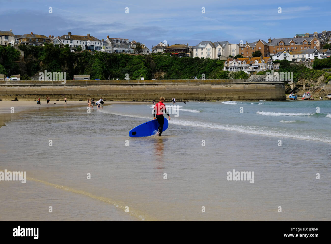 Il surfer che entra in mare a Newquay in Cornovaglia Foto Stock