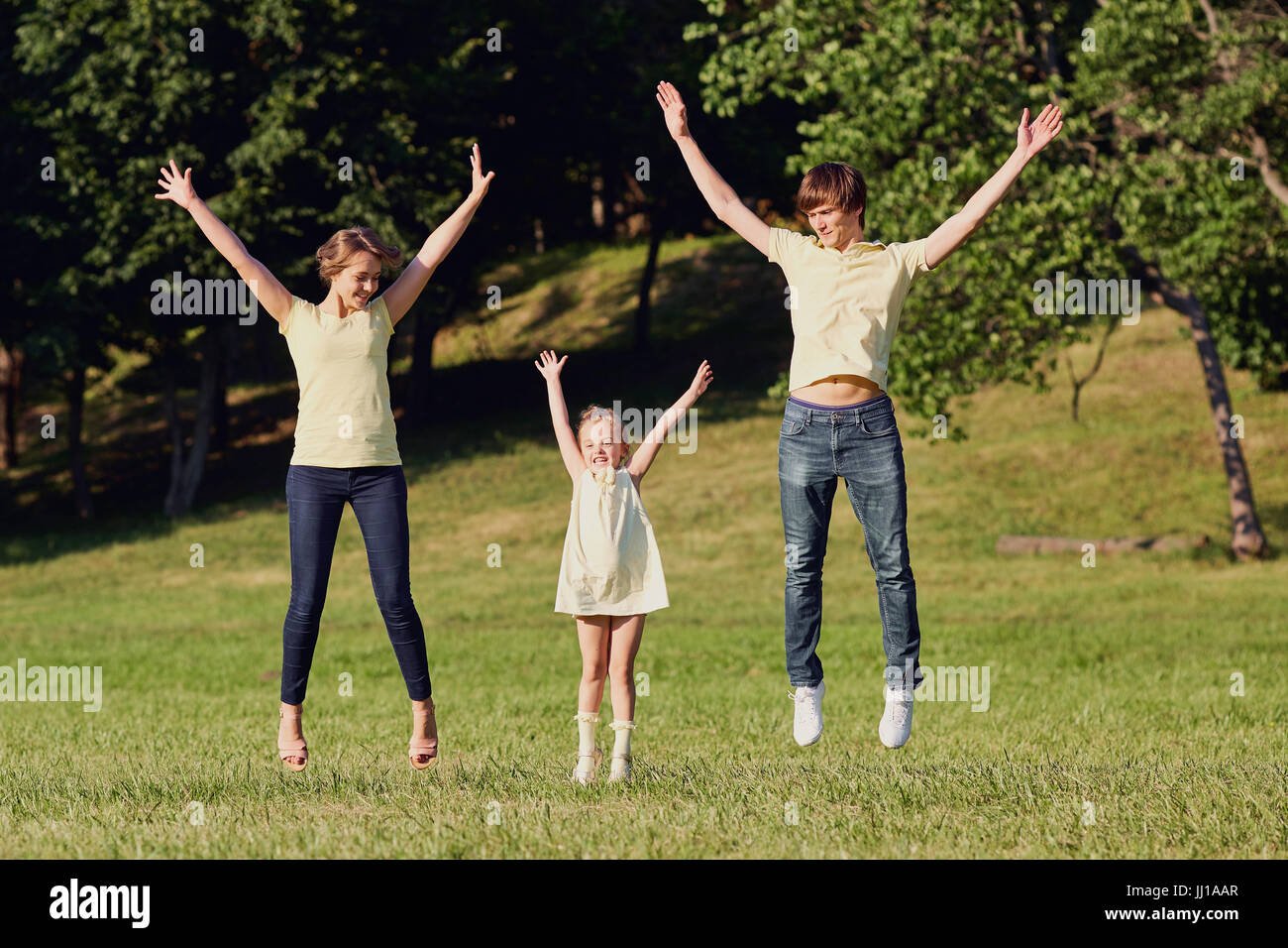 La famiglia felice nel parco con le mani. Foto Stock