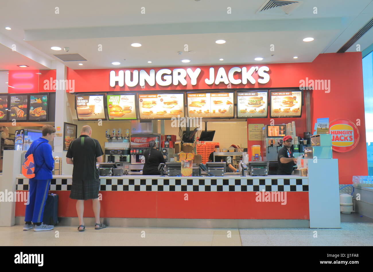 La gente visita Hungry Jacks fast food all'Aeroporto di Melbourne in Australia. Foto Stock