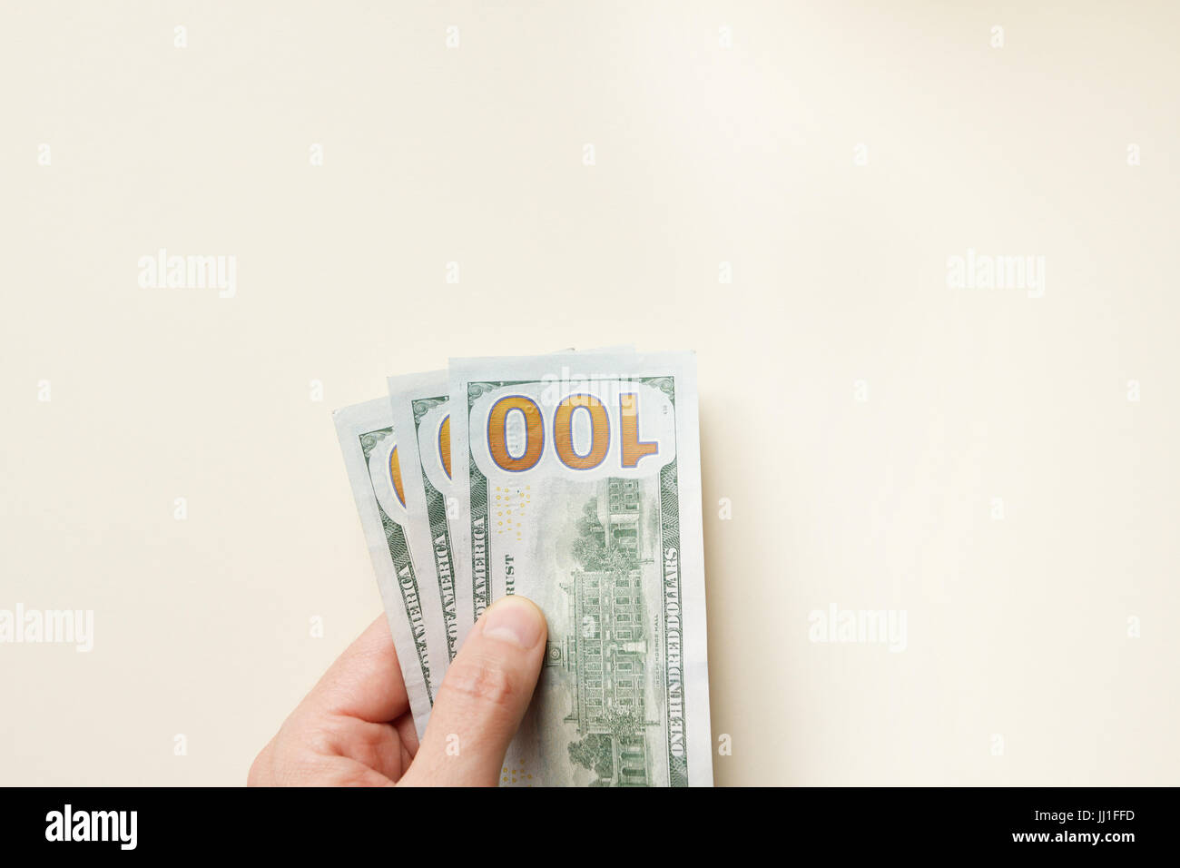Mano che tiene isolate banconote da cento dollari su sfondo leggero: Finanza, risparmio, investimento e concetto di denaro. Foto Stock