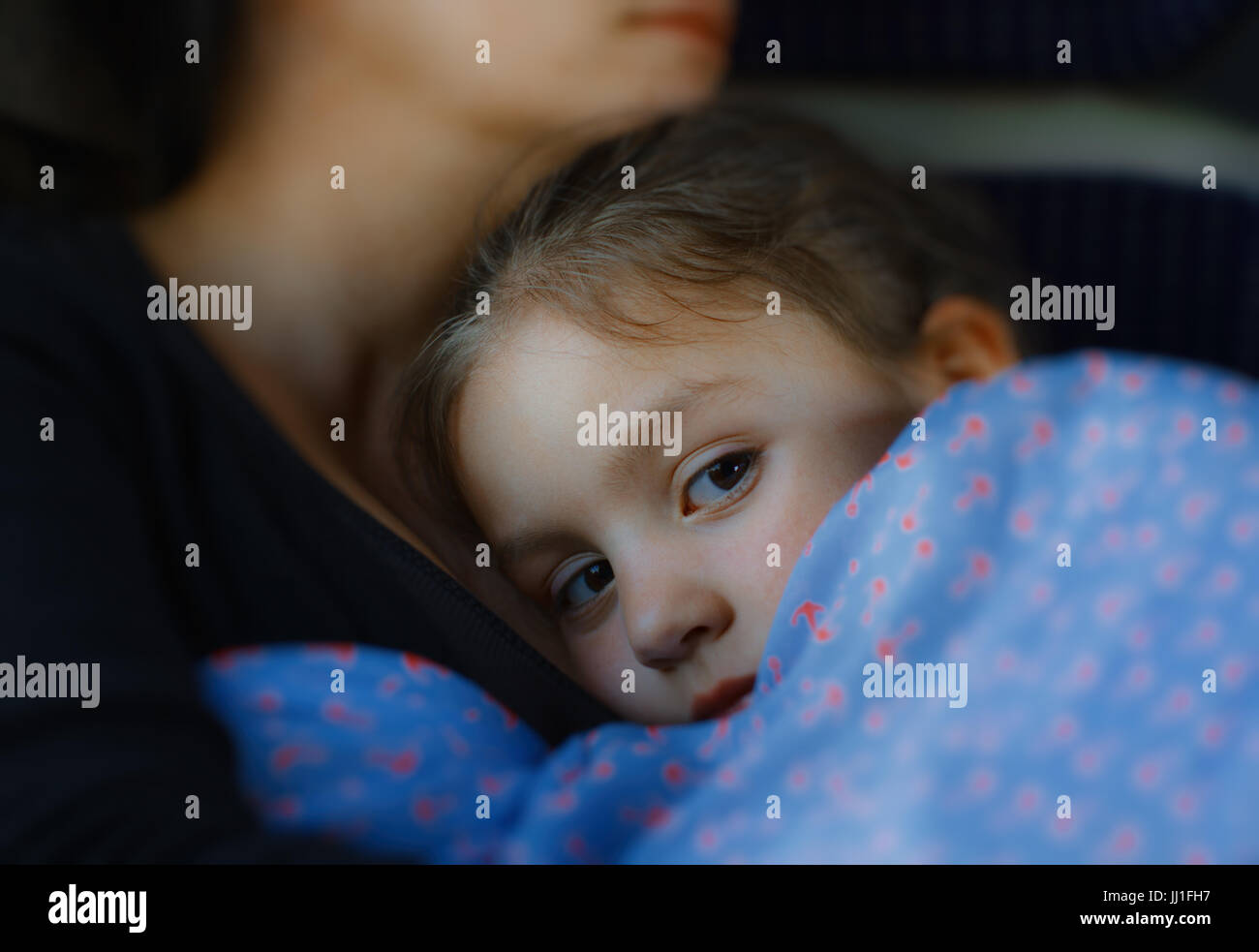 Bambina cerca di dormire nella sua madre di braccia Foto Stock