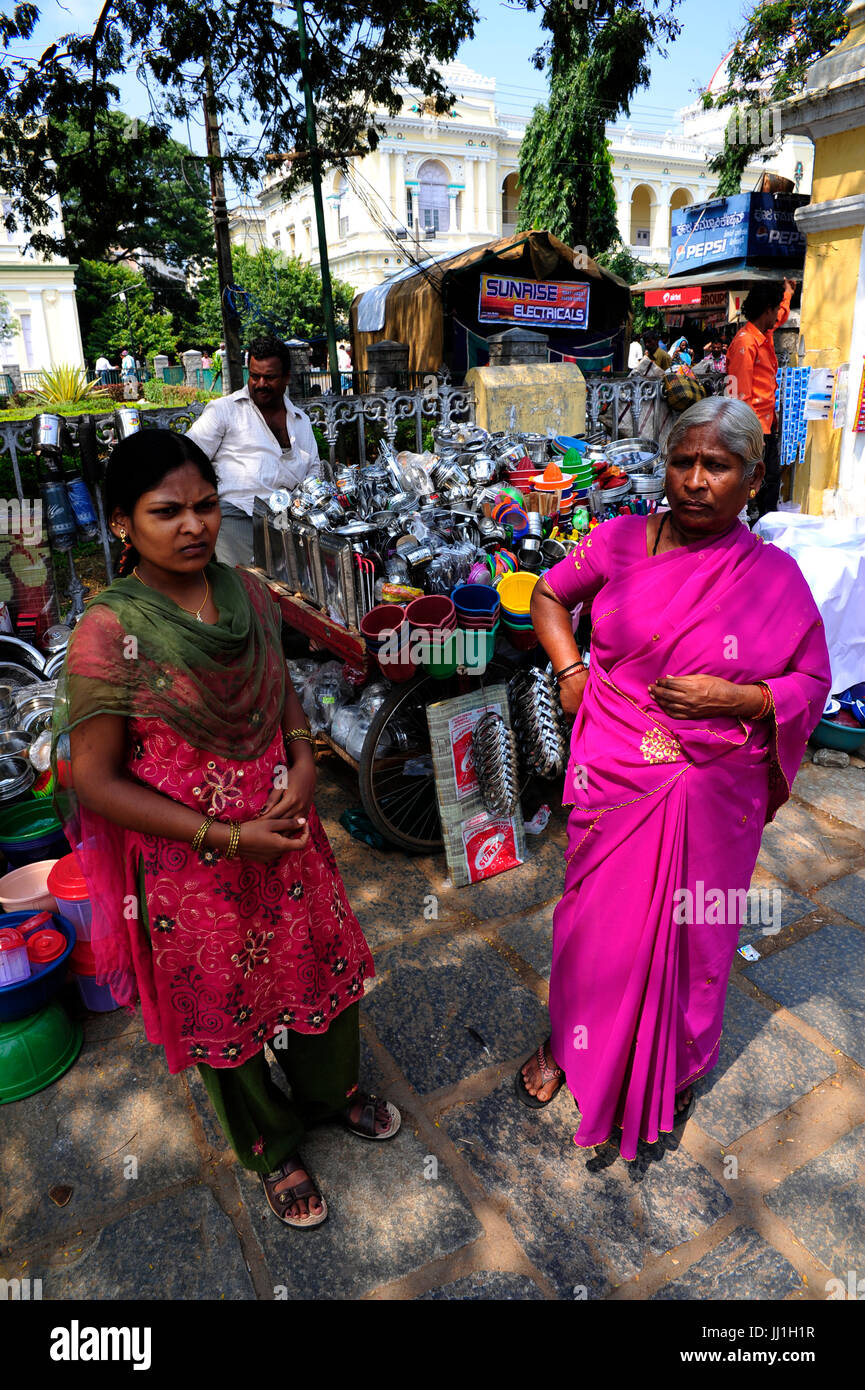 Indian womans di fronte strada in stallo la vendita di articoli per la casa a Mysore, Karnataka, India Foto Stock