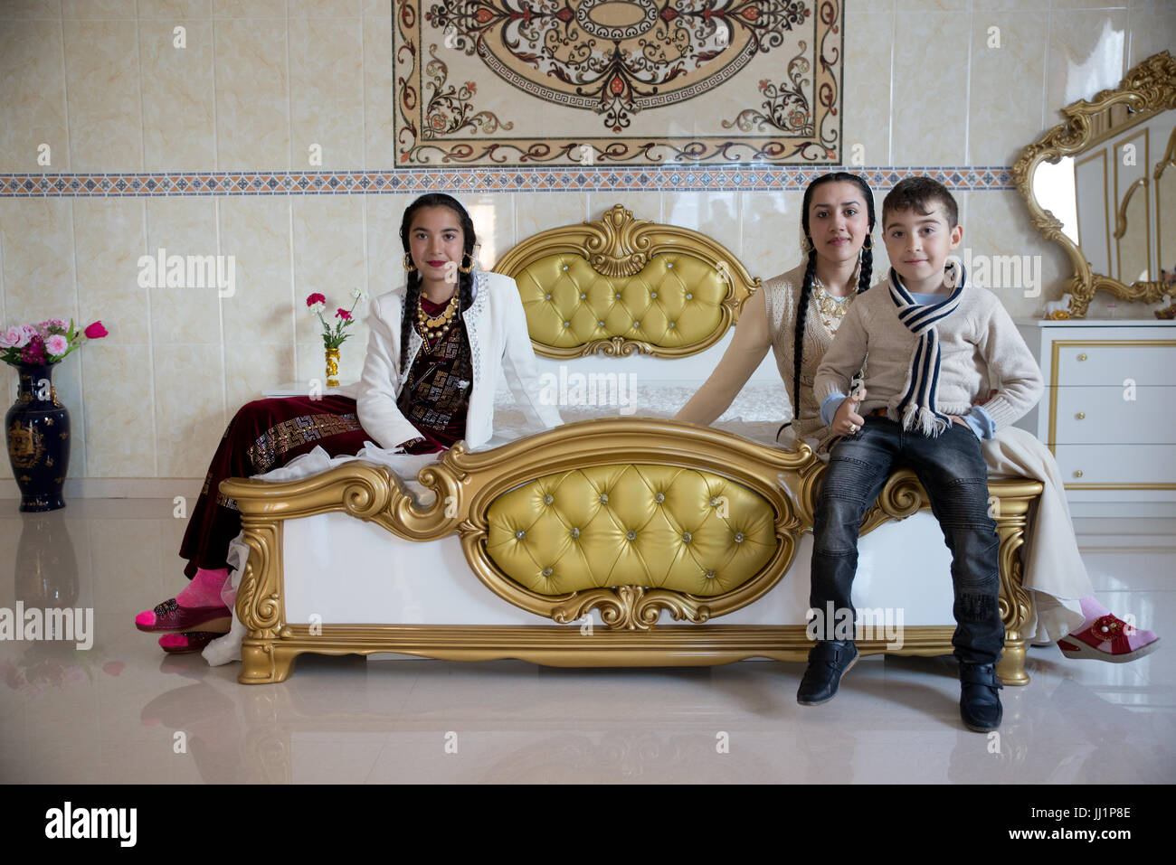 I bambini di un facoltoso Roma famiglia zingara in posa la lussuosa camera da letto della loro casa Ivanesti, Romania Foto Stock