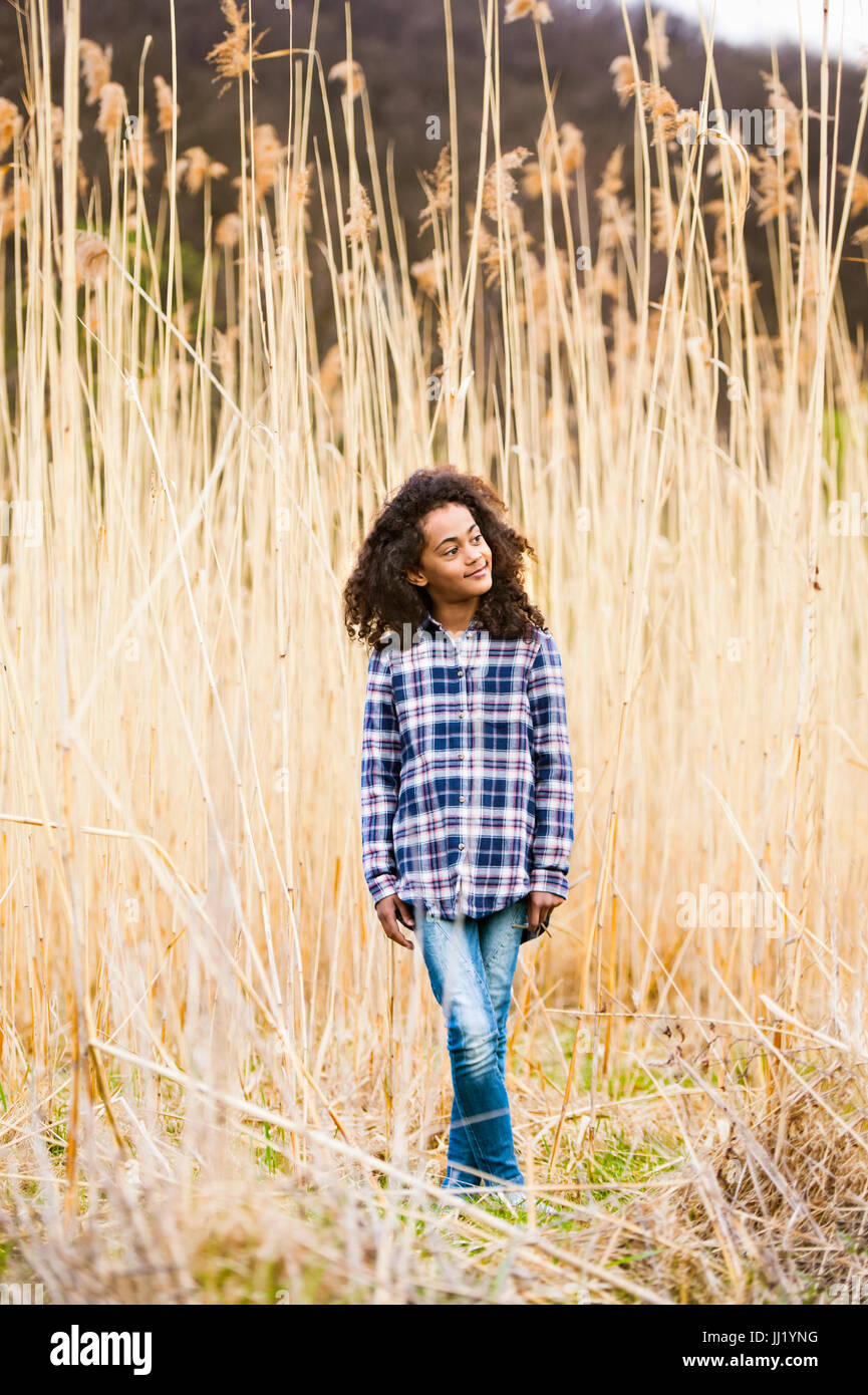 African American Girl in maglietta controllati in esterno e in campo. Foto Stock