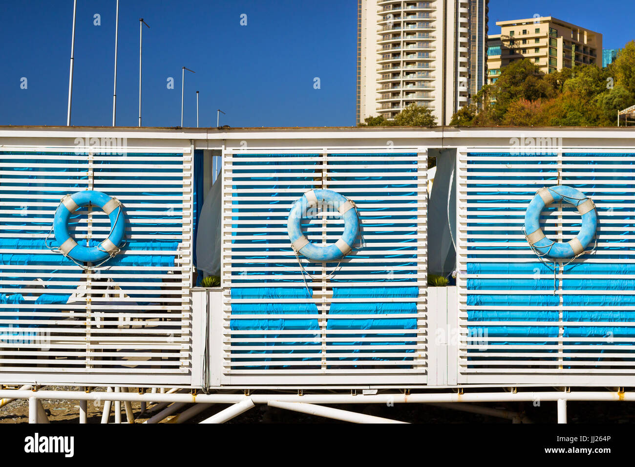 Ciambella blu appeso alla parete in legno tenda spiaggia sulla costa di una Costa ghiaiosa nel resort city Sochi. Spiaggia rilassante vacanza in costiera tenda d'estate. Archi Foto Stock