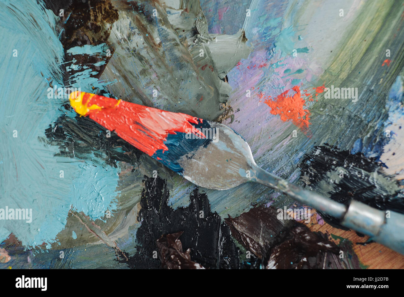 Una spatola con la pittura ad olio di colori su sfondo pallette Foto stock  - Alamy