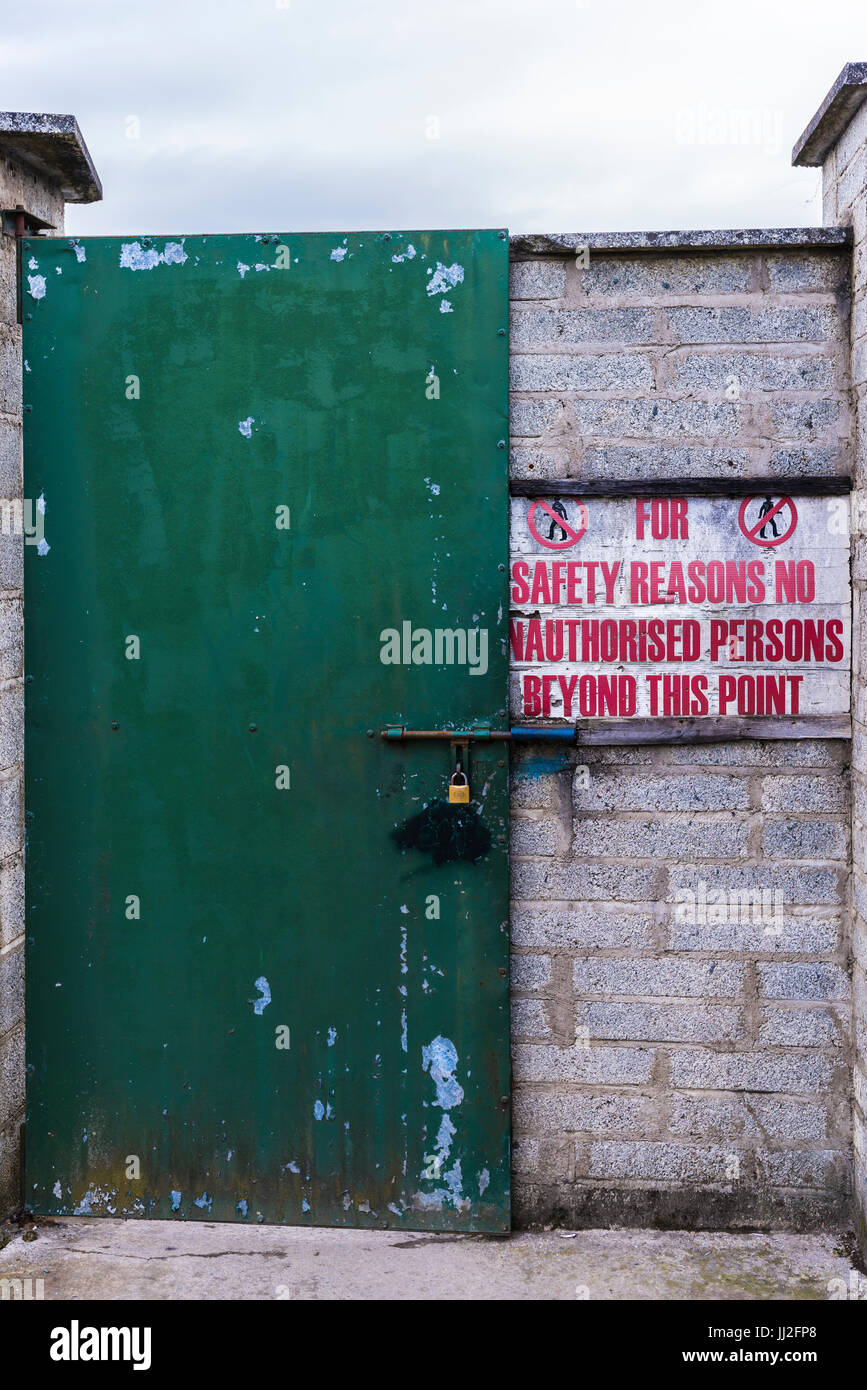 Segno all'bloccato lo sportello in acciaio in un sito industriale " per motivi di sicurezza non alle persone non autorizzate oltre questo punto'. Foto Stock