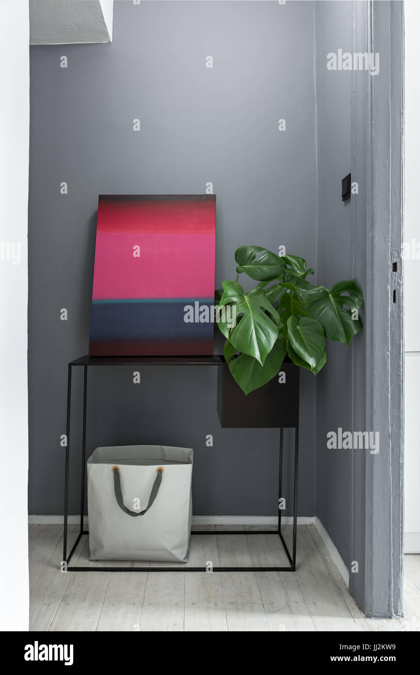 Home grigio interno con tavola nera, pittura moderna e pianta Foto Stock