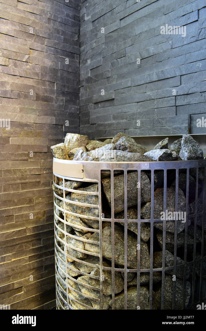 Sauna stufa con muro di pietra su sfondo nella sauna finlandese. Foto Stock