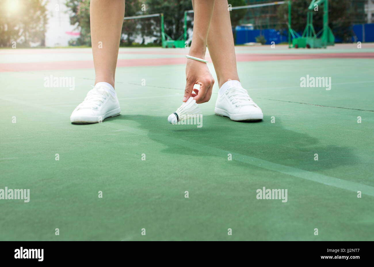 Ragazza la raccolta di badminton palla sul campo Foto Stock