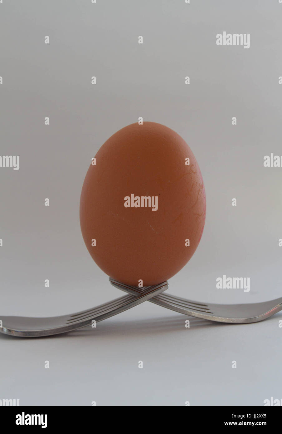 Uovo astratta bilanciato su una coppia di forcelle. Foto Stock