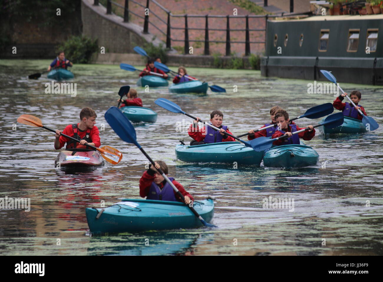 I ragazzi e il loro apprendimento istruttore di kayak sul Grand Union Canal a Londra Foto Stock