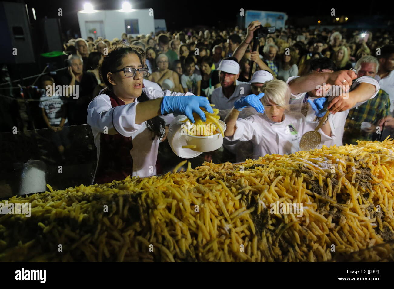 (170718) -- NAXOS, luglio 18, 2017 (Xinhua) -- volontari servono patatine fritte di patate durante l'evento sull'isola di Naxos, Grecia, 15 luglio, 2017. Ci sono voluti più di 1.500 kg di materie Naxos patate, 22 enorme cauldrons, il duro lavoro di 40 volontari per rompere il Guinness World Record per la cottura il più pesante del lotto di patatine fritte. La bilancia elettronica che pesato le patate fritte leggere 554 kg, 100 kg in più rispetto al precedente record del mondo fissato nel 2014 in Eagles, Idaho negli Stati Uniti. La manifestazione si è svolta durante il 8° Naxos Sagra della Patata, uno dei più popolari sagre gastronomiche del Mare Egeo. Foto Stock