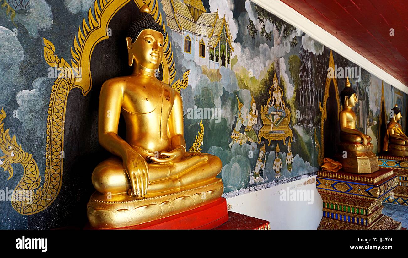 Immagine del Buddha statue con pittura murale di sfondo sul dietro al Wat Phratrat Doi Suthep, tempio thailandese di Chiang Mai, Thailandia. Foto Stock