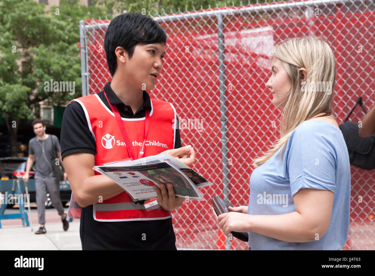 Un canvasser per 'Salva i bambini' organizzazione parla di una donna sui contributi ricorrenti (donazioni) e figlio sponsoring. Foto Stock