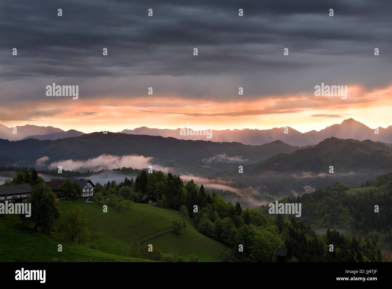 Sunrise con nebbia sulle montagne di Kamnik Savinja Alpi con picco Storzic sulla destra in Skofjelosko sulle colline vicino a Ljubljana Slovenia Foto Stock