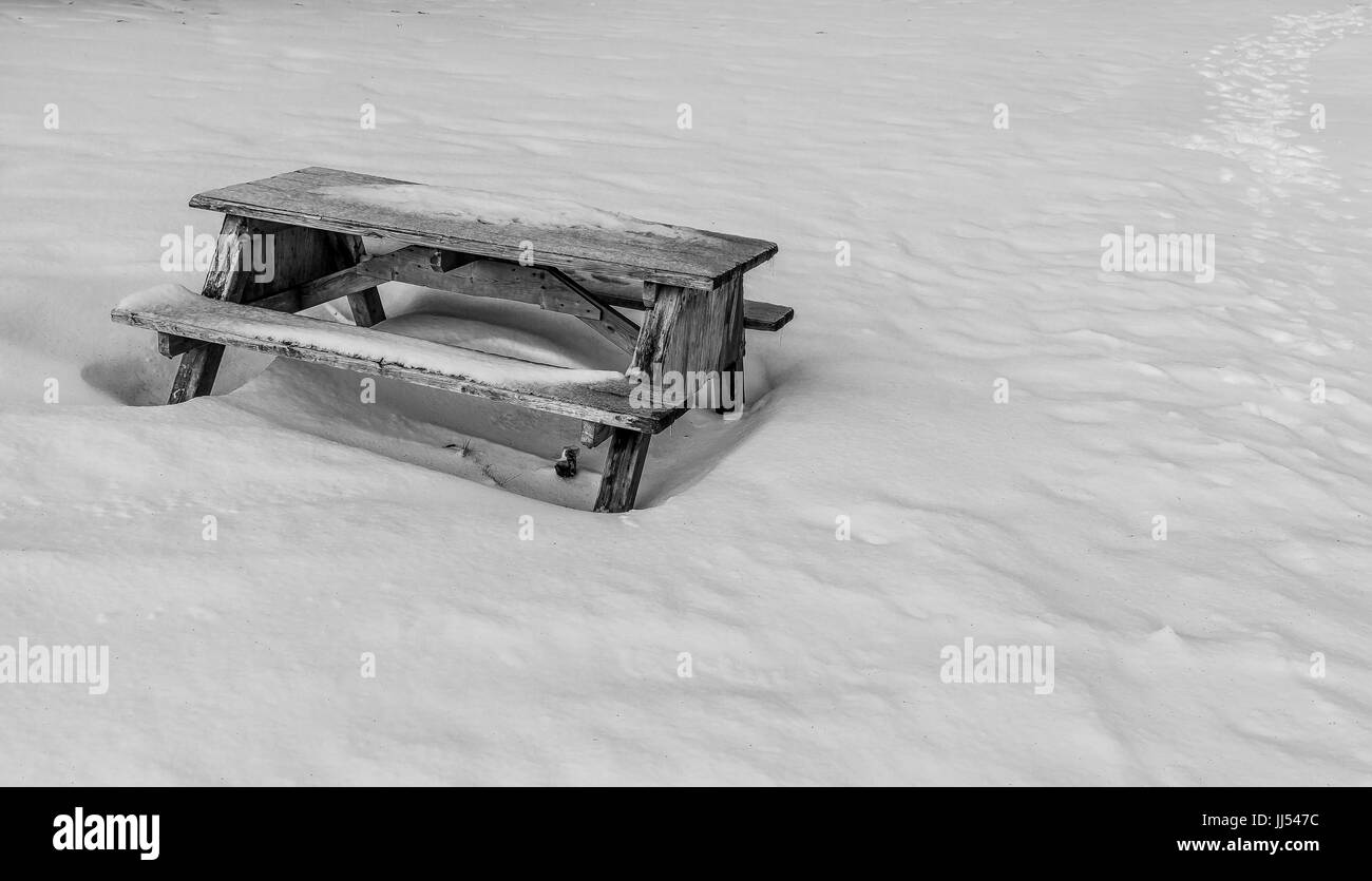 Banco di picnic circondato dalla neve Foto Stock