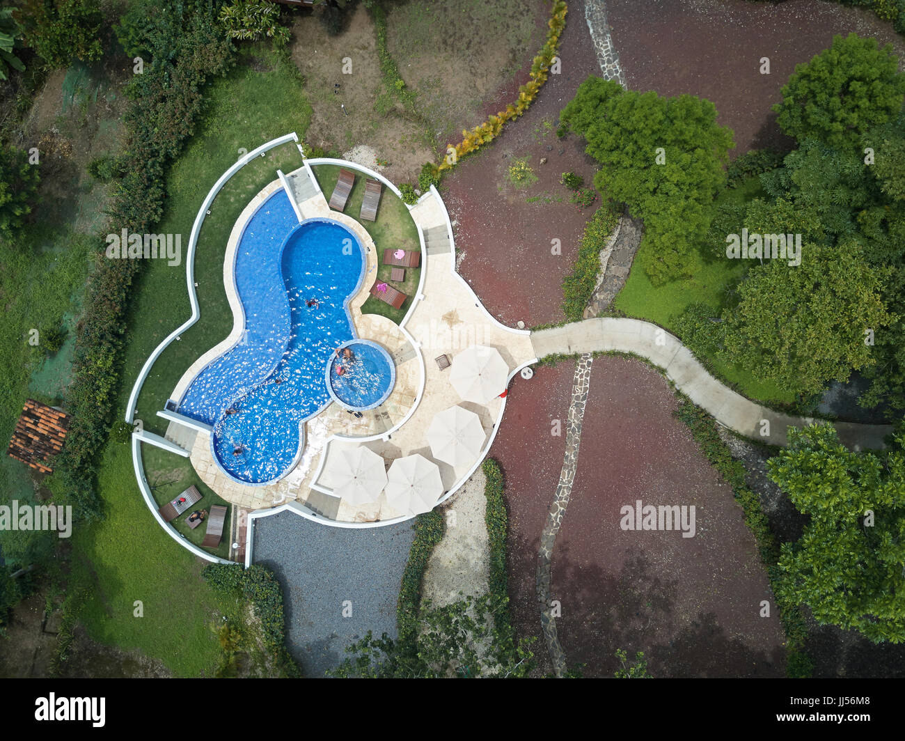 Vista aerea sulla piscina con acqua blu nel giardino naturale sullo sfondo Foto Stock
