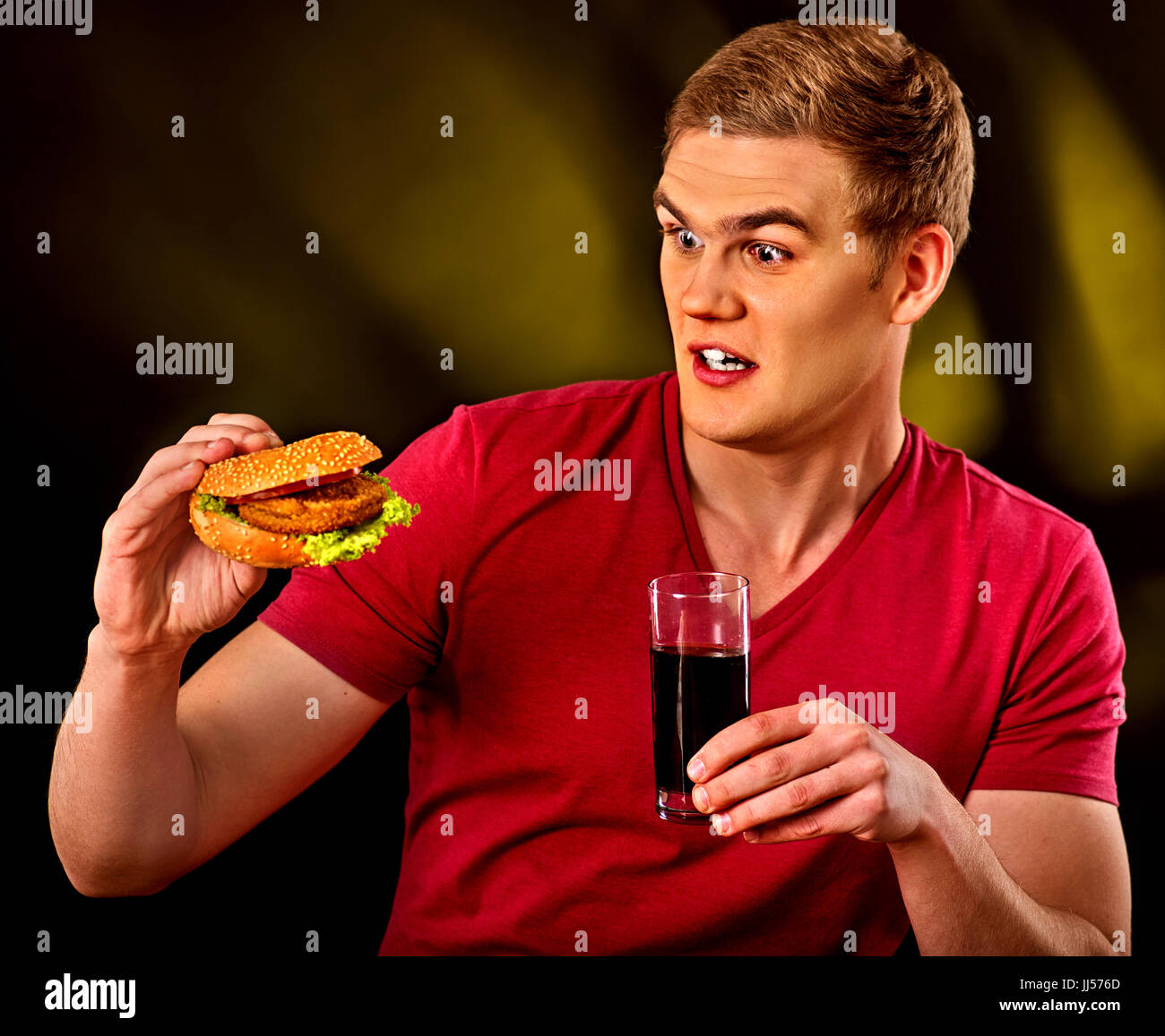 L'uomo mangiare patatine e hamburger. Foto Stock