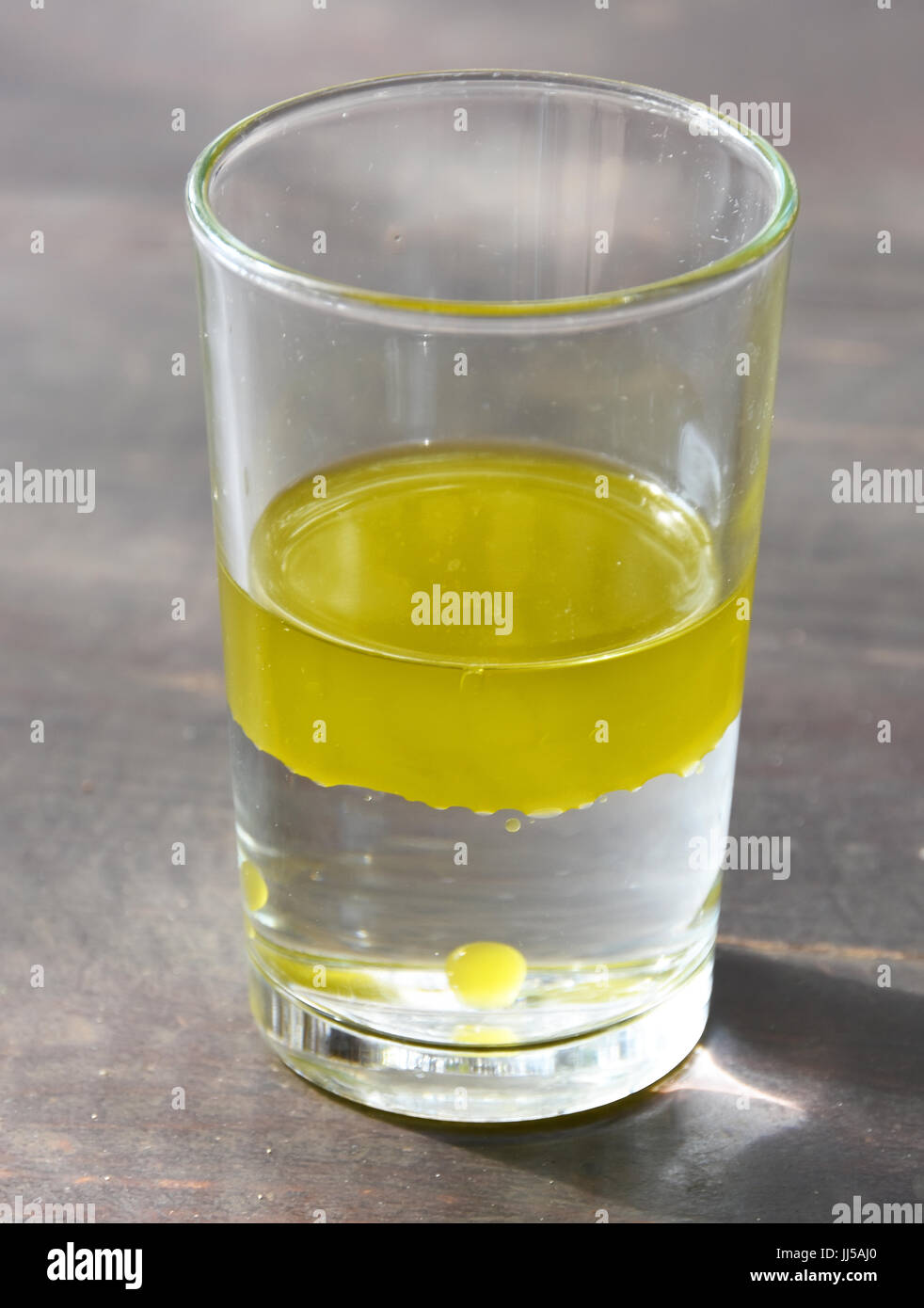 Olio di oliva galleggiare su acqua Foto Stock