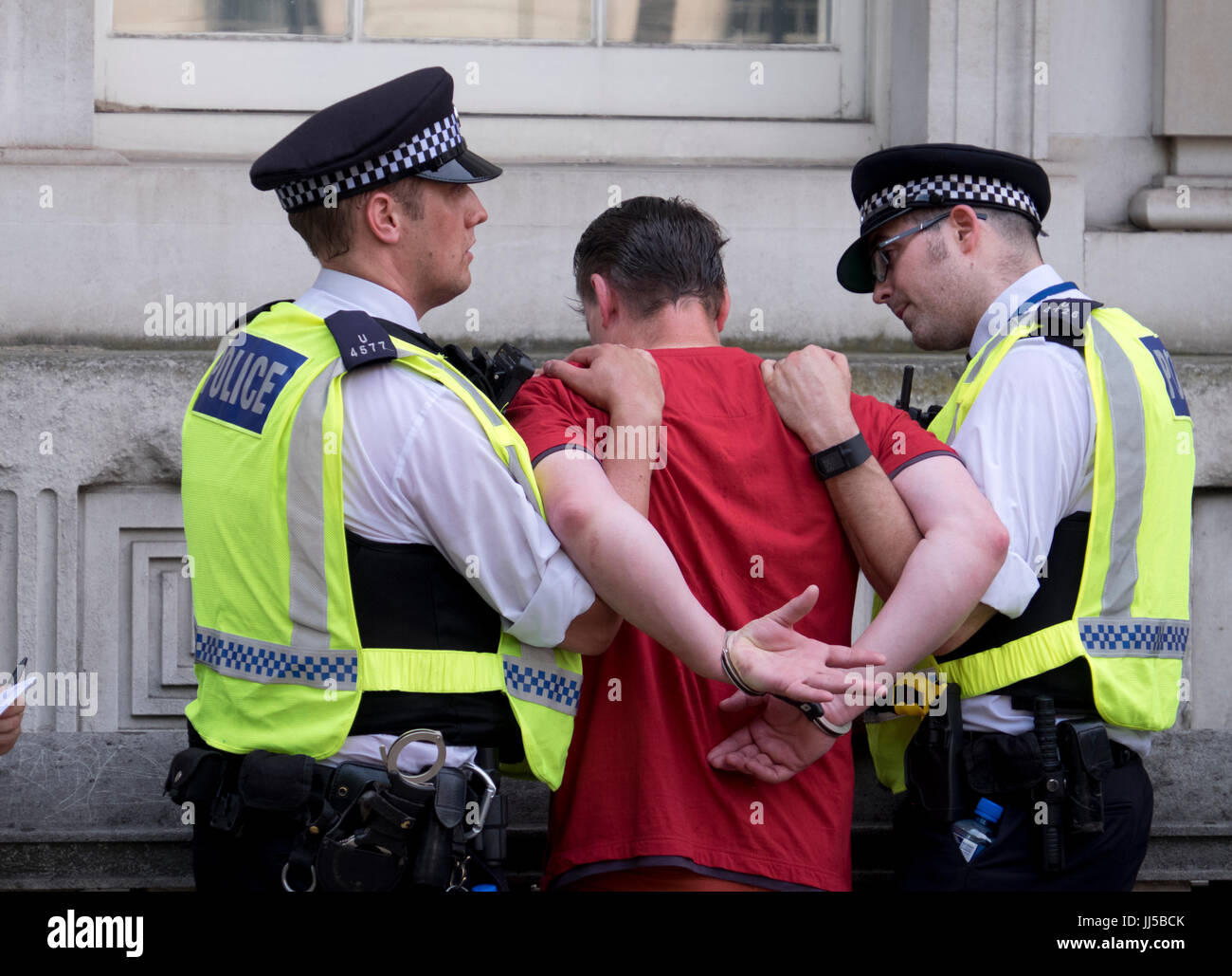 Polizia e arresto handcuffing un uomo a Londra Foto Stock