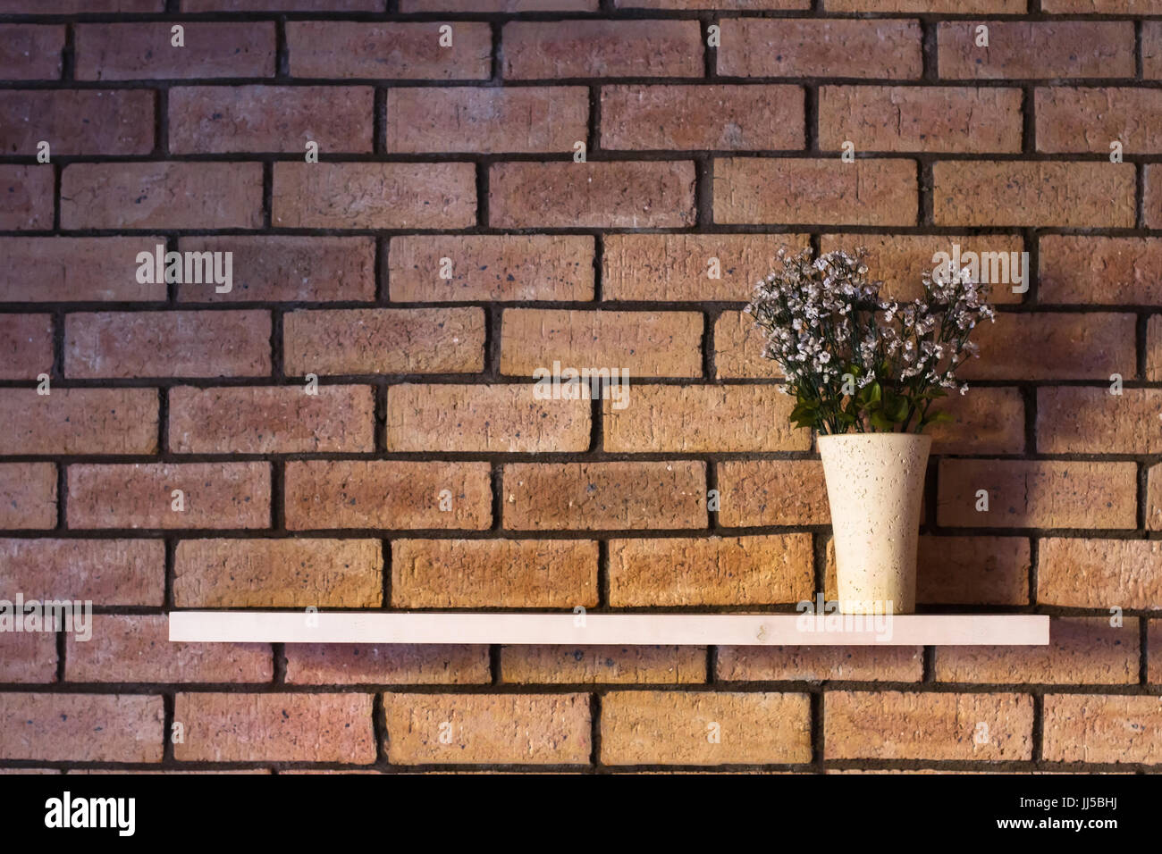 Semplice progettazione di interni, Vaso di fiori sulla mensola su un muro di mattoni con copyspace Foto Stock