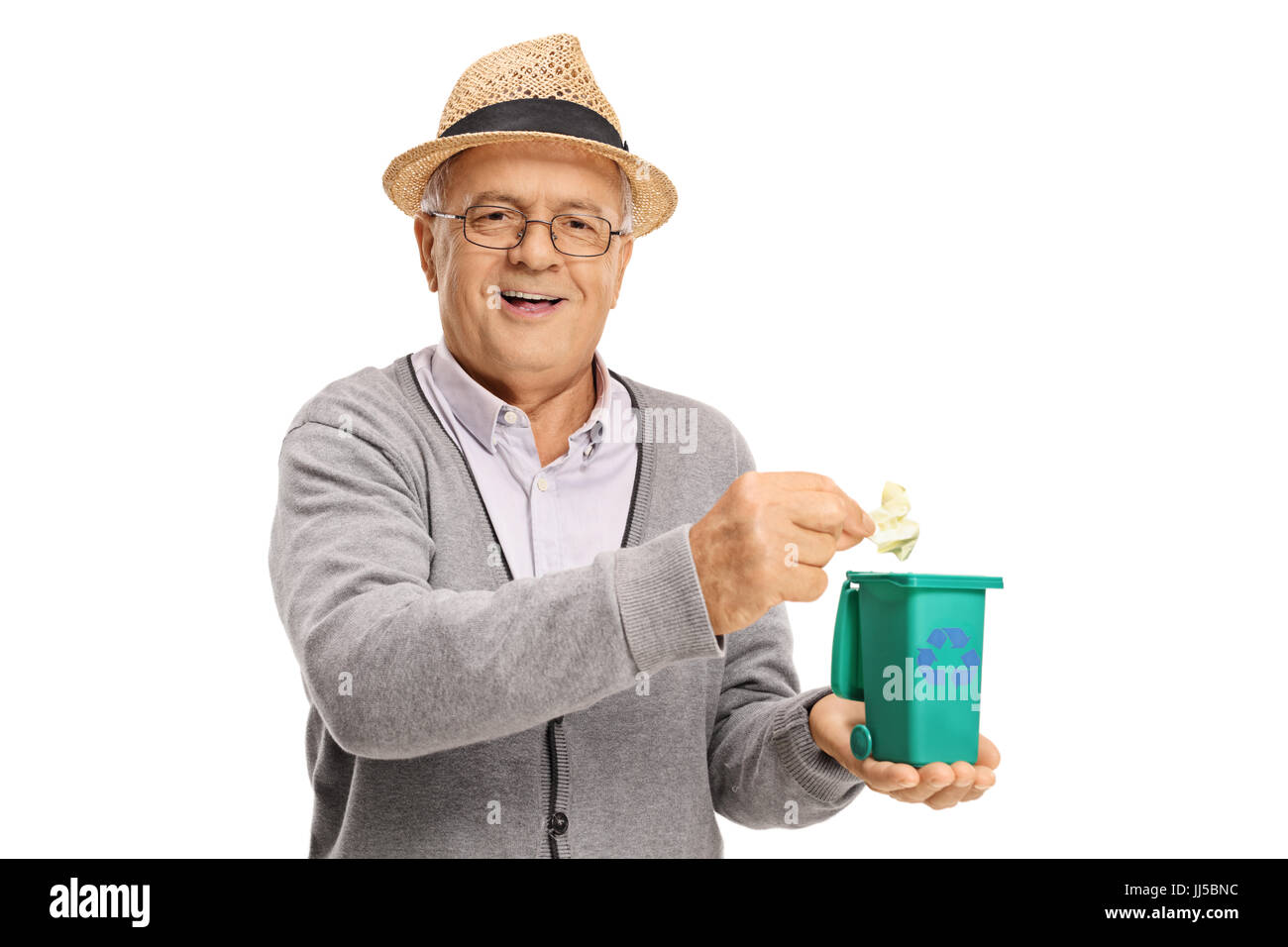 Senior lanciando un pezzo di immondizia in un piccolo contenitore di riciclaggio isolati su sfondo bianco Foto Stock