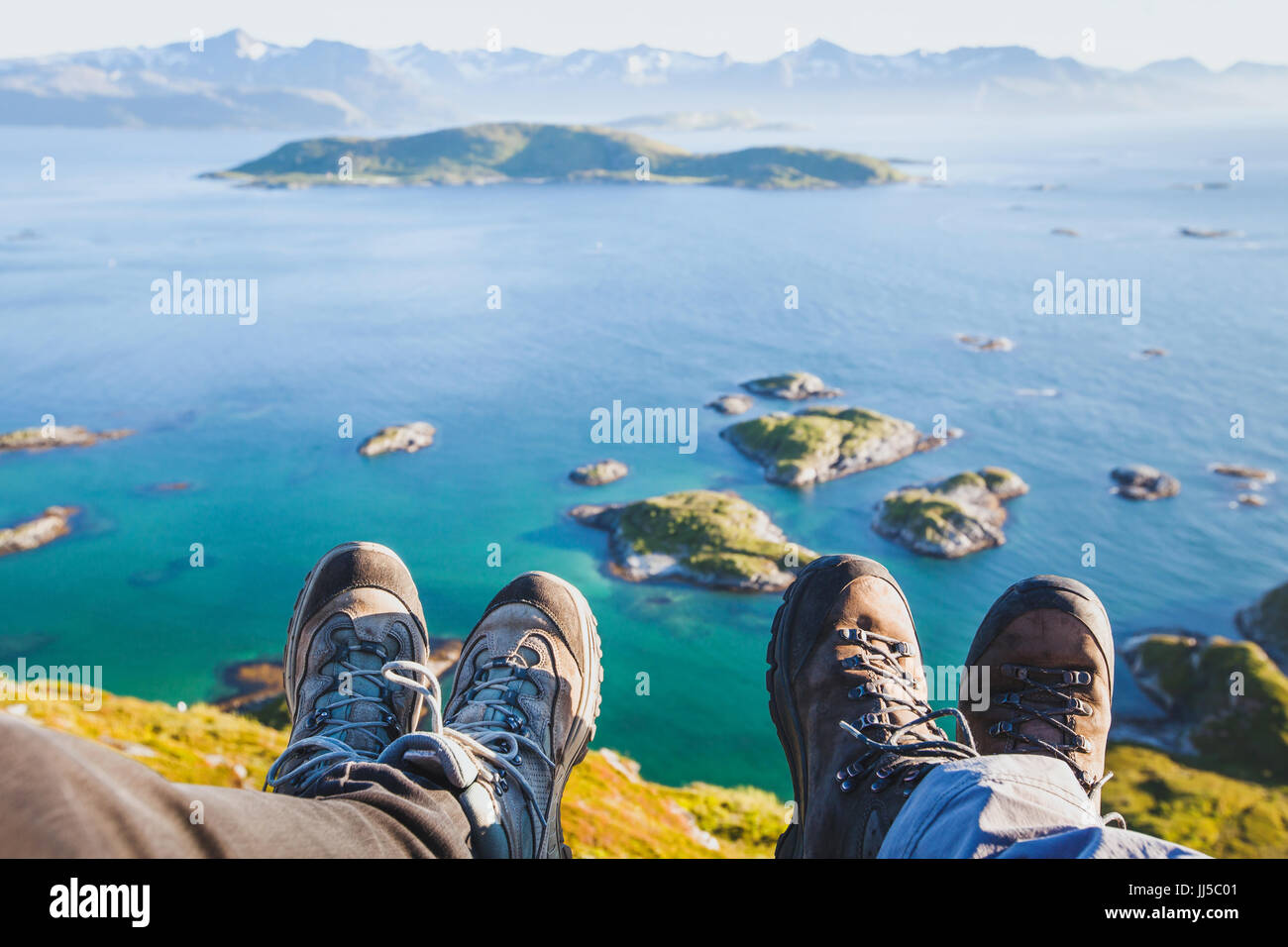 Le scarpe da trekking a piedi di coppia di viaggiatori escursionisti seduti sulla cima della montagna in Norvegia con la bellissima vista, trekking selfy con norvegese l Foto Stock