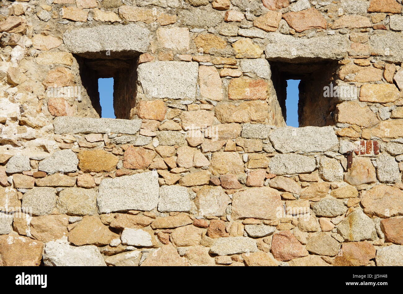Strette finestre su un muro medievale di guardare il enamy senza stato girato. Foto Stock