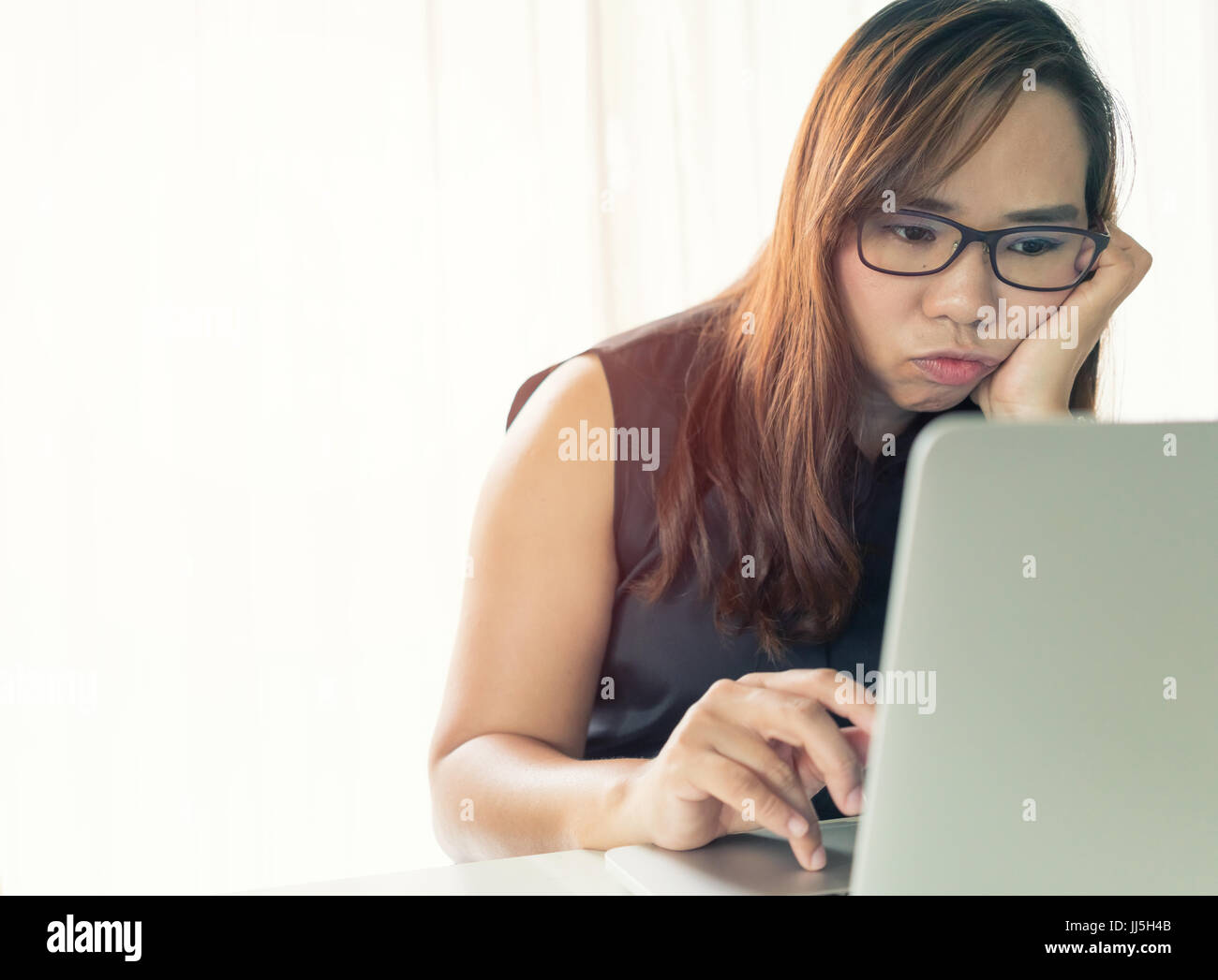 Donna al lavoro su computer portatile in ufficio Foto Stock