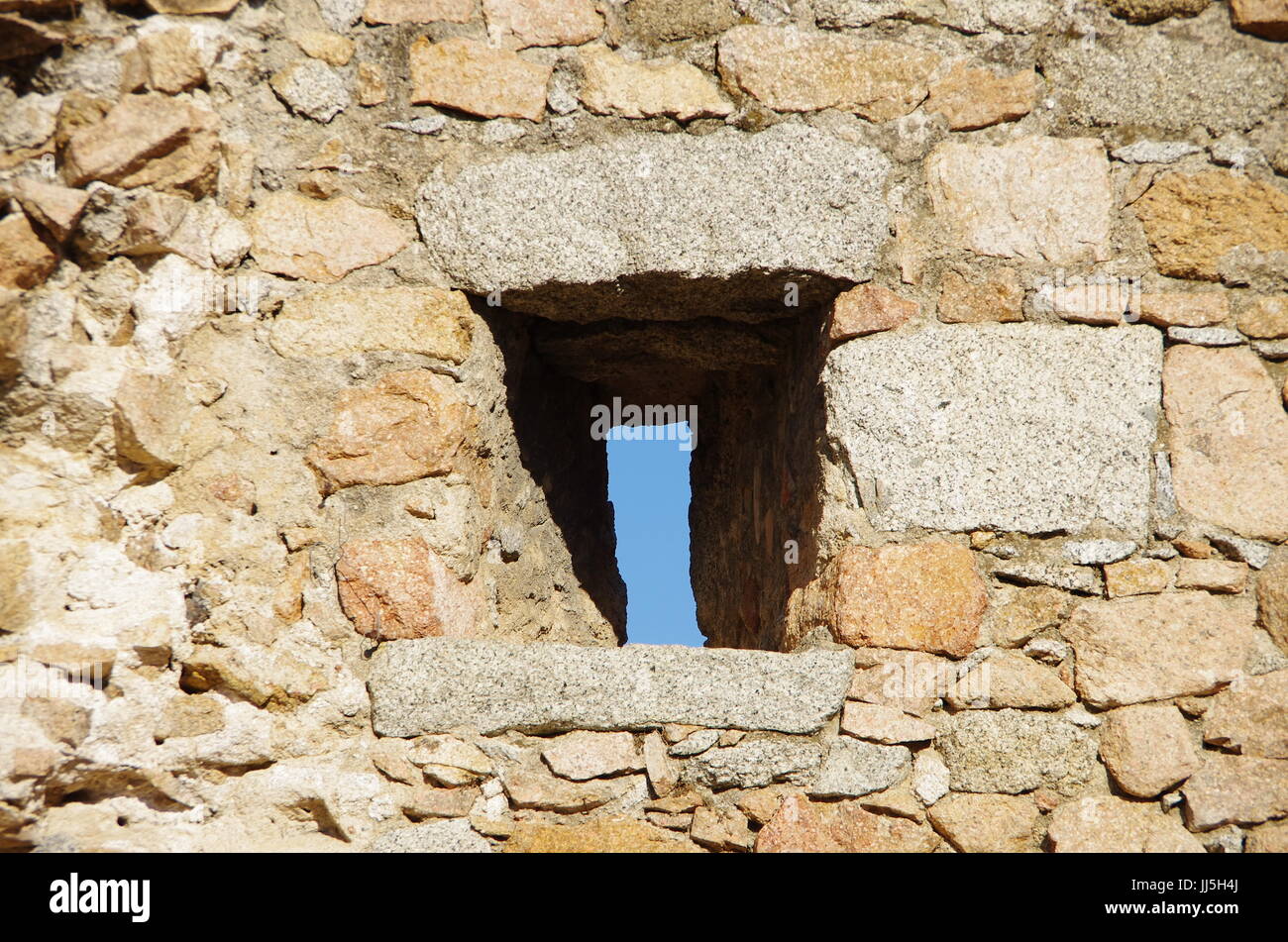 Strette finestre su un muro medievale di guardare il enamy senza stato girato. Foto Stock