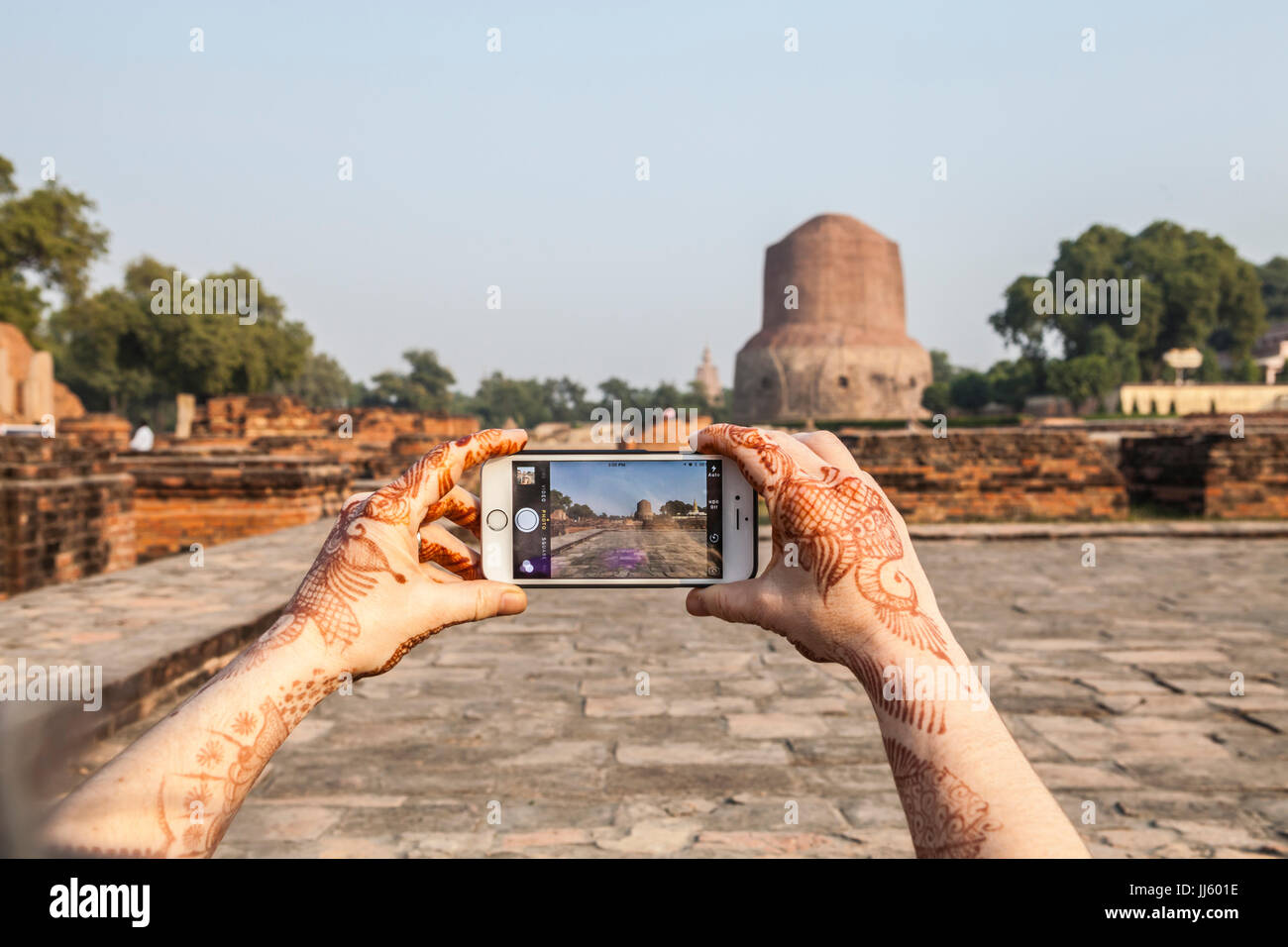 Una donna di prendere una foto di Dhamekh Stupa a Sarnath, in India con il suo iPhone. Foto Stock