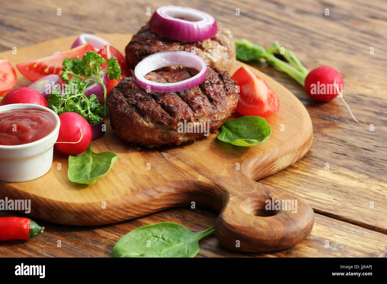 In casa hamburger di manzo con cipolla sul tagliere Foto Stock