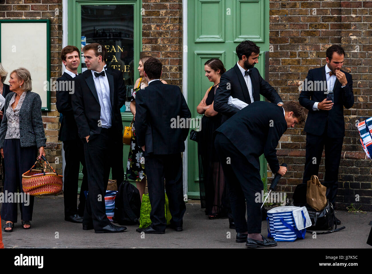 Giovani appassionati di opera con i loro cestini da picnic arriva a Lewes stazione ferroviaria en route al Teatro dell'opera Glyndebourne, Lewes, Sussex, Regno Unito Foto Stock