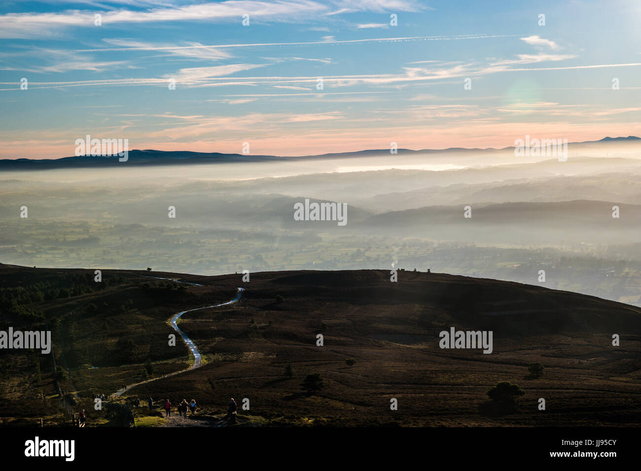 Percorso di salita ad alto livello in heather moorland con misty valley. Foto Stock
