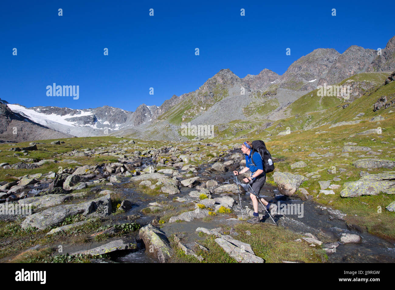 Un escursionista è camminare vicino a Lac des Dix nelle Alpi Svizzere. Il terreno è fangoso dopo il ghiacciaio si è ritirata. Foto Stock