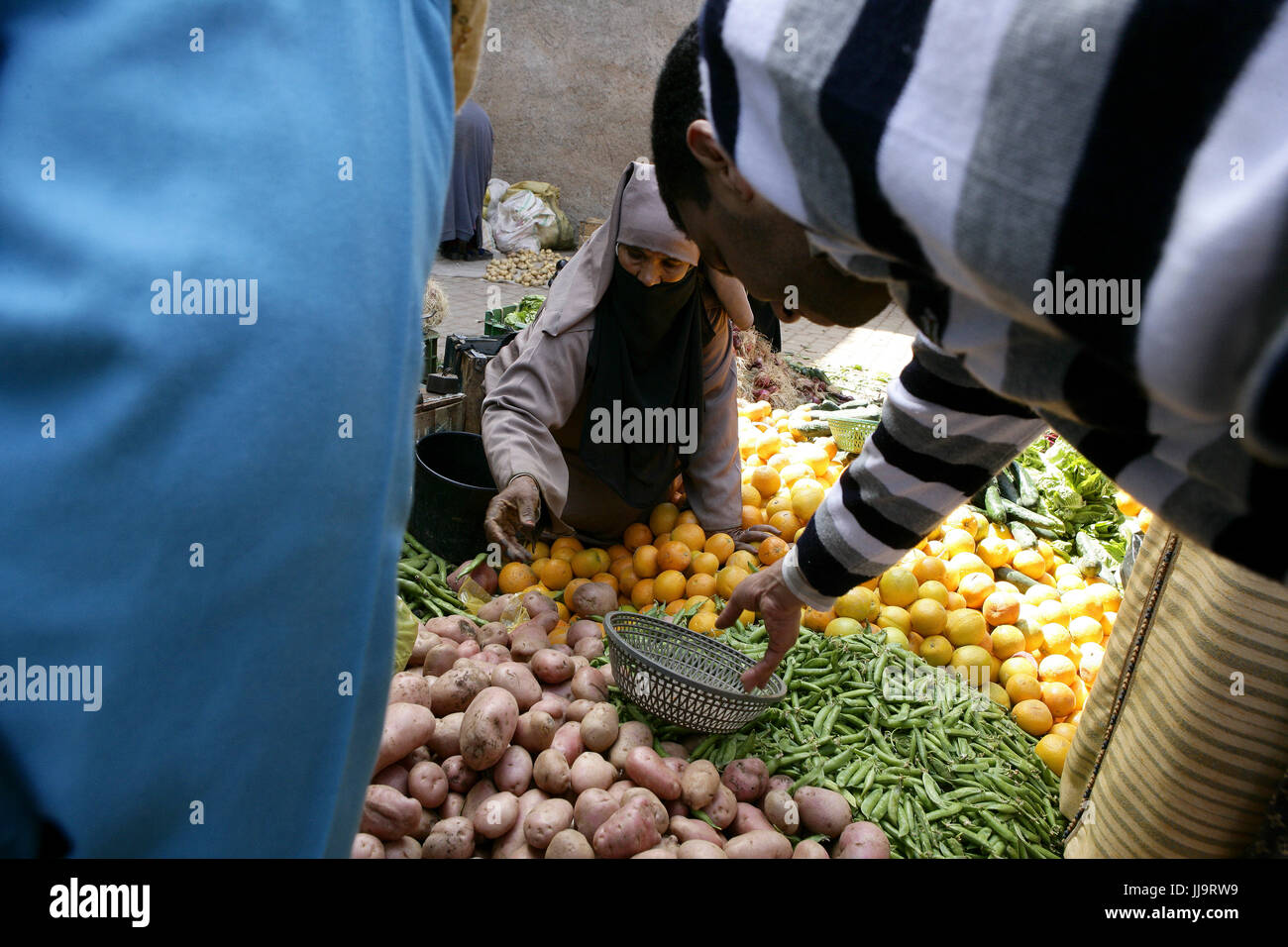 Una donna seels verdure su strada nella medina di Marrakesh trimestre Foto Stock