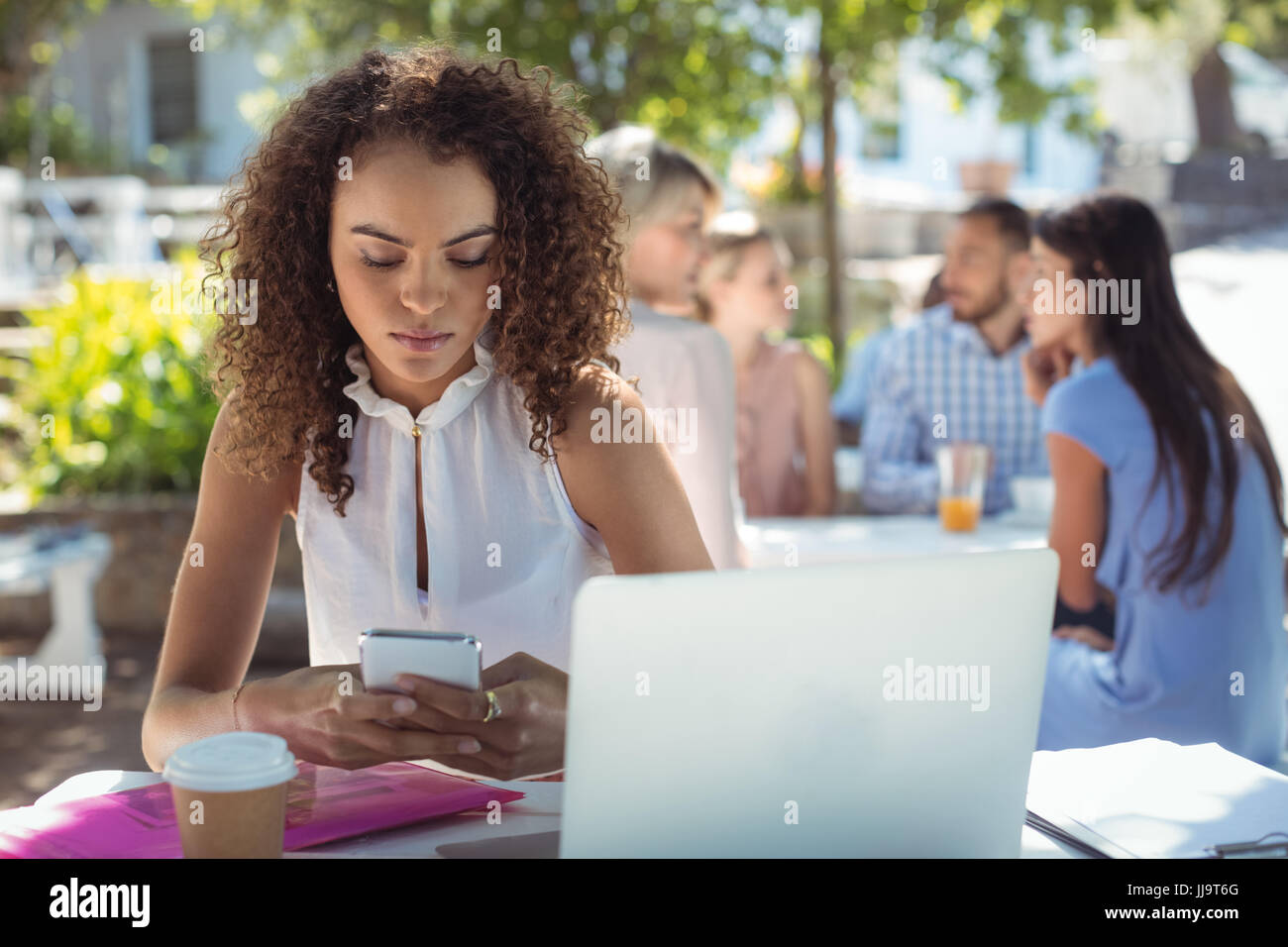 Bella donna utilizzando il telefono cellulare nel ristorante Foto Stock